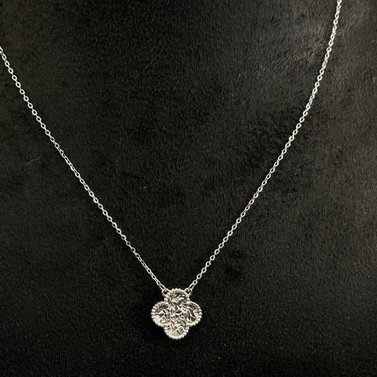 Silver necklace with a heart-shaped pendant on a dark background