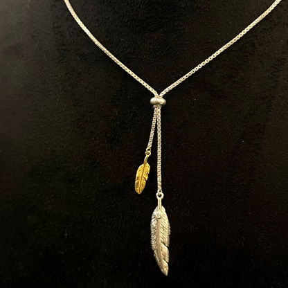 Necklace with feather pendants on a black mannequin