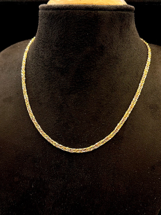 Gold chain necklace on a black mannequin bust