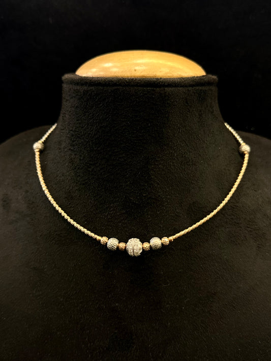 necklace with beads on a black mannequin bust against a black background