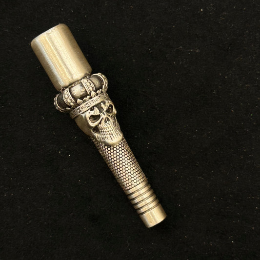 Decorative metal object with skull design on a black background