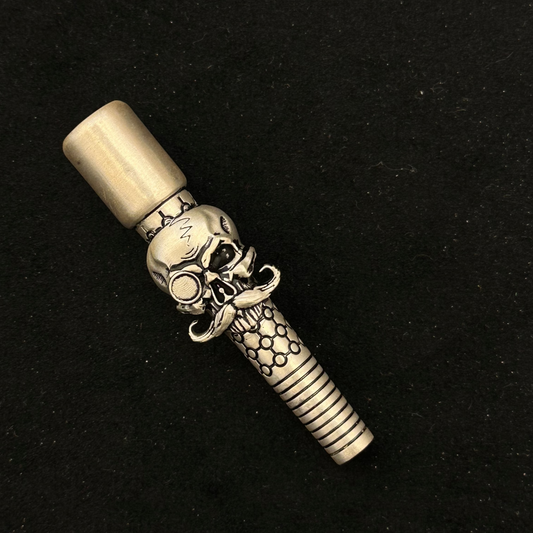 Decorative object with skull and dagger design on a black background