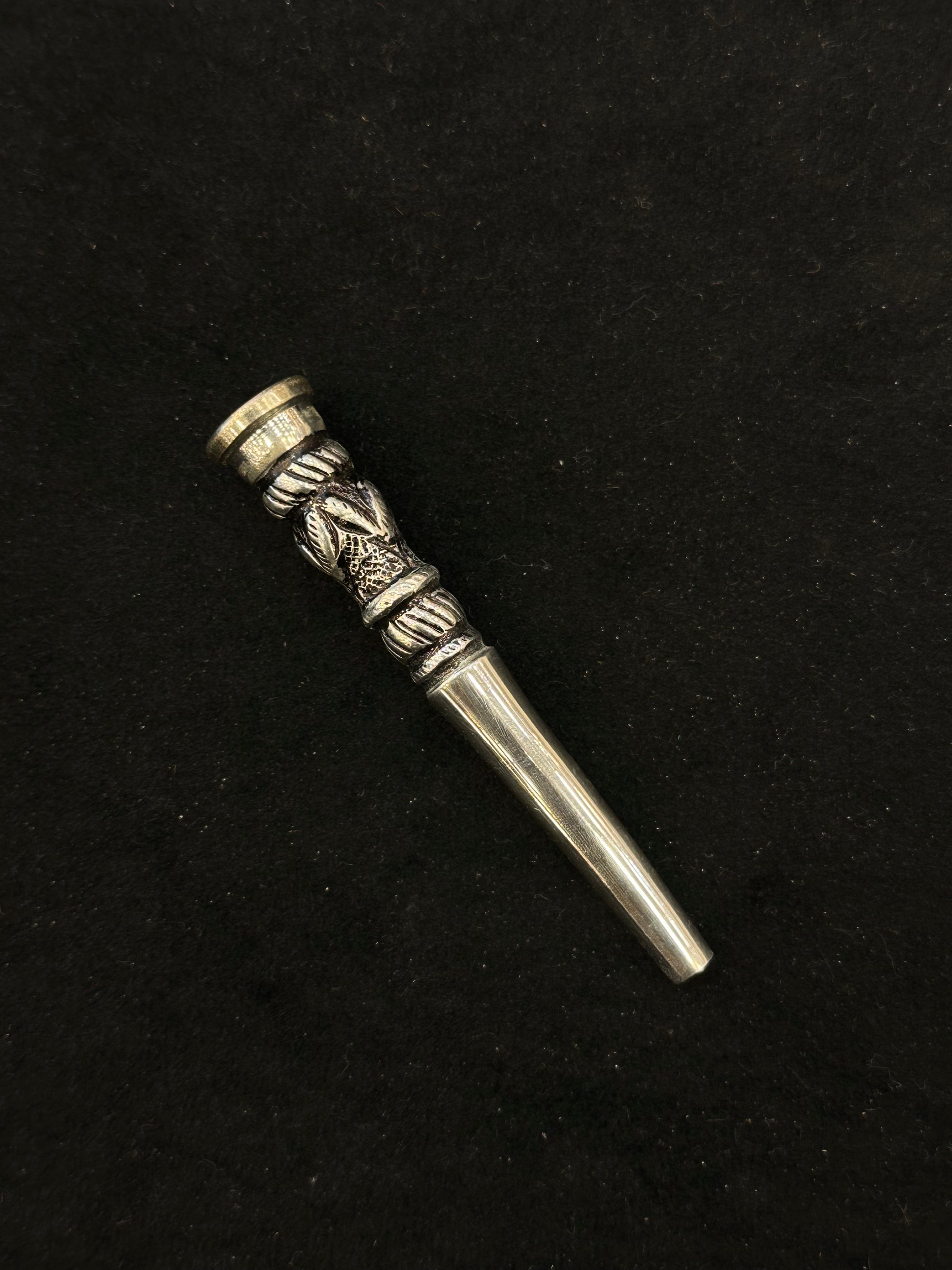 Silver decorative object on a black background