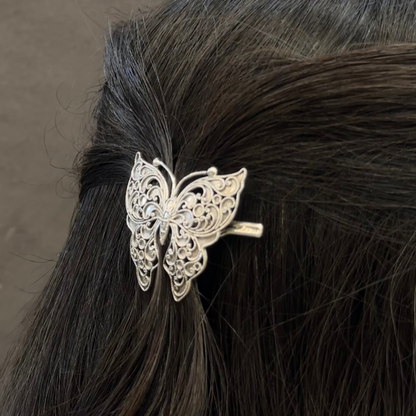 Butterfly hair clip on black hair against a brown background