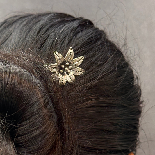 Hair bun with a decorative hairpin against a neutral background