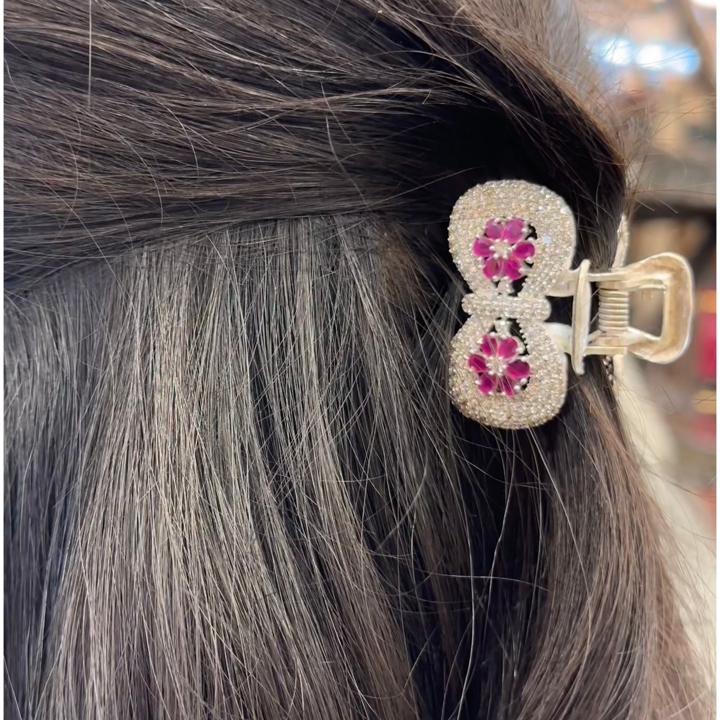 Close-up of a decorative hair clip in gray hair with blurred background