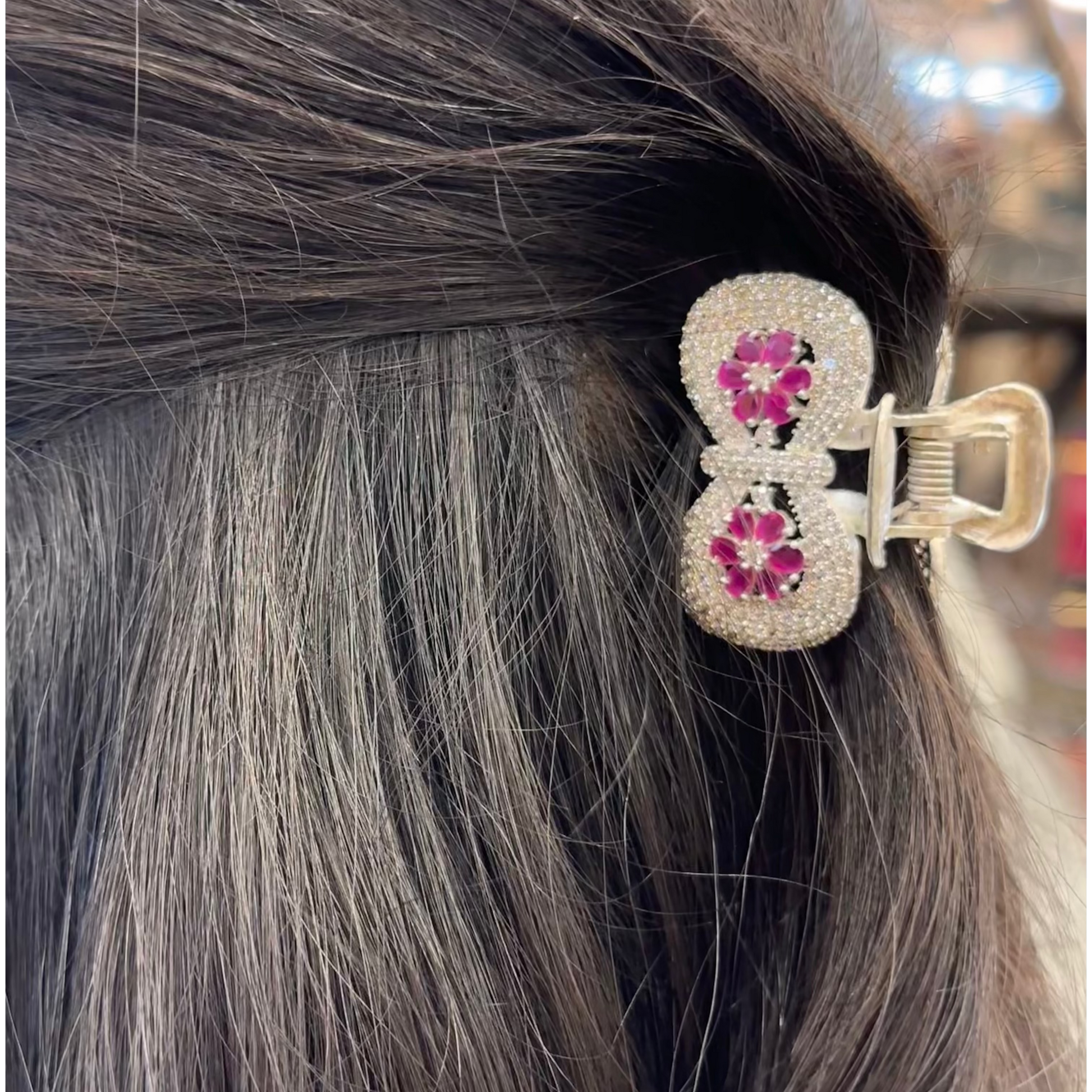 Close-up of a decorative hair clip in gray hair with blurred background