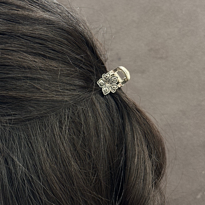 Hair tie with floral design in a person's hair against a gray background